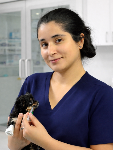 Jeanine White smiling in a red plaid shirt and tortoise shell glasses